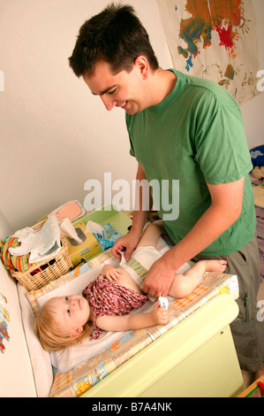 Padre cambiando un pannolino per bambini Foto Stock