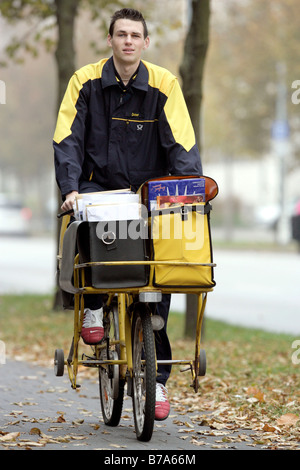 Mailman della Deutsche Post AG, Deutsche Post, in sella a una moto in Regensburg, Baviera, Germania, Europa Foto Stock