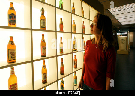 Visitatore femmina per quanto riguarda le bottiglie di birra da tutto il mondo in Deutsches Hopfenmuseum, il luppolo tedesco Museo in Wolznach in de Foto Stock