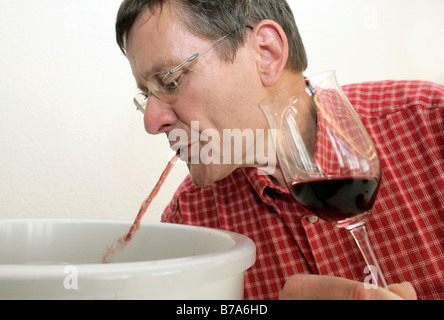 Esperto di vino lo sputare, sboccatura il vino durante l'analisi sensoriale per i vini di qualità in un ufficiale di test di qualità presso il St Foto Stock