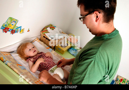 Padre cambiando un pannolino per bambini Foto Stock