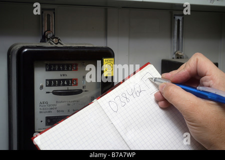 Mano prendendo nota del consumo di elettricità, misuratore di elettricità in casa indipendente, Coblenza, Renania-Palatinato, Germania, Europa Foto Stock