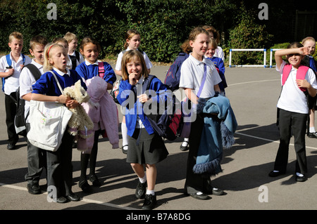 Gruppo di primaria i bambini i ragazzi e le ragazze in un parco giochi scuola Inghilterra REGNO UNITO Foto Stock