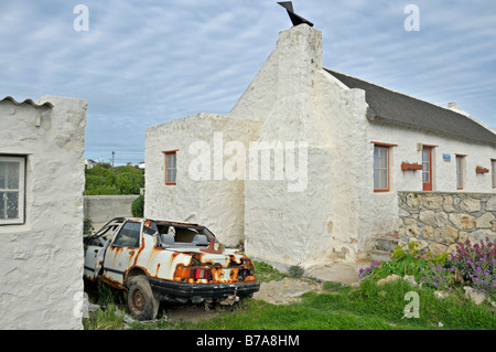 Rusty auto rottamata e case di pescatori nero le famiglie in Kassiesbaai vicino Arniston, West Kap, Sud Africa Foto Stock