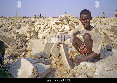 Uomo Afar la raccolta di grandi blocchi di sale da salina Foto Stock