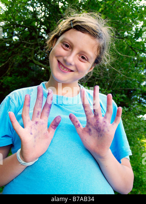 13 enne ragazza con colorate in blu le mani da mirtilli Foto Stock