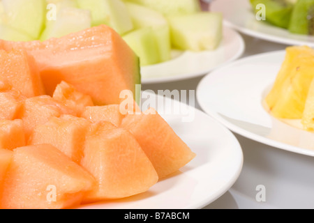 Fette di frutta esotica su piastre, zucchero di melone e melone Honeydew, ananas, kiwi e uva Foto Stock