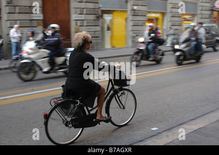 Italia Firenze Street scene di donna su biciclette e motociclette Foto Stock