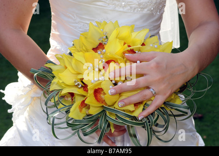 Una chiusura di un brides mani tenendo il suo bouquet di nozze Foto Stock