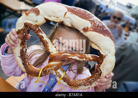 Ragazza, 5, con pretzel, Oktoberfest a Monaco di Baviera, Baviera, Baviera, Germania, Europa Foto Stock