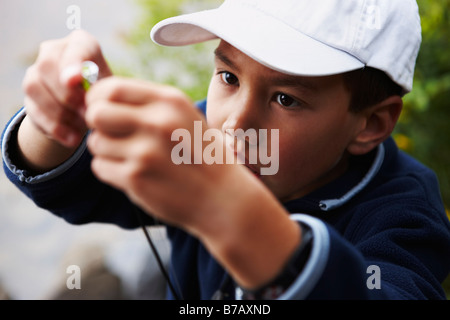 Ragazzo mettendo esca sulla canna da pesca, Algonquin Park, Ontario, Canada Foto Stock