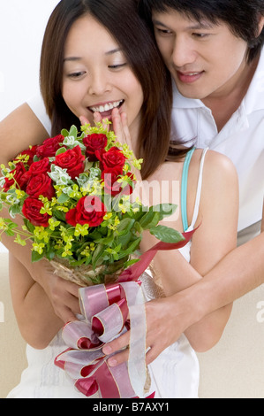 Giovane uomo dando un mazzo di fiori per la sua ragazza Foto Stock