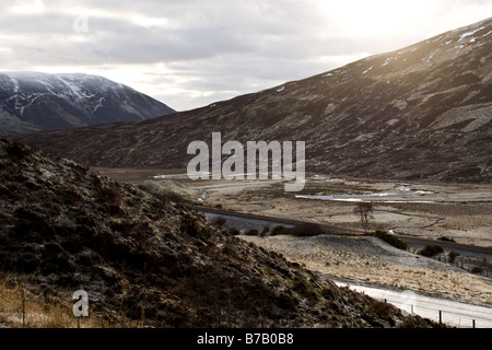 I binari ferroviari che corre attraverso il freddo inverno le montagne nelle Highlands scozzesi Foto Stock