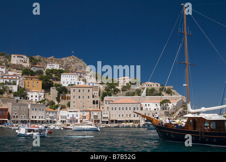 I passeggeri sulla prua di un tradizionale in legno barca a vela godetevi la vista all'arrivo nel porto di Hydra, Grecia Foto Stock