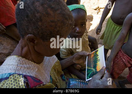 Vecchia donna guardando un New York City cartolina in Pays Dogon del Mali Foto Stock