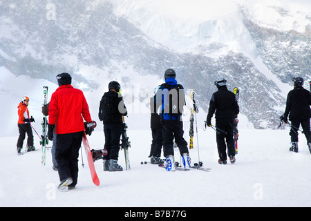 Gli sciatori e gli snowboarder a Allalin stazione superiore preparazione per sci e snowboard, Saas Fee svizzera Foto Stock