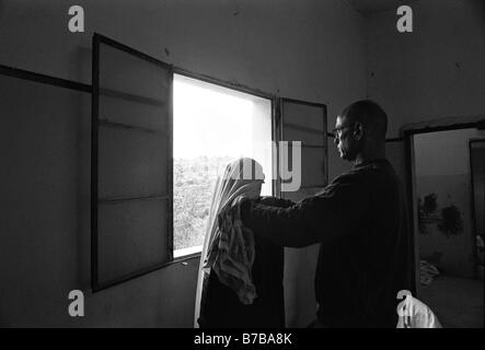 Dr. Yigal Shochat dal PHR Medici per i diritti umani che controllano una donna palestinese durante una visita di clinica mobile nella Cisgiordania Israele Foto Stock