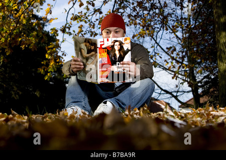 Un uomo che legge un FHM magazine Foto Stock