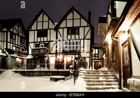 Case Tudor con brillanti luci su una notte invernale Foto Stock
