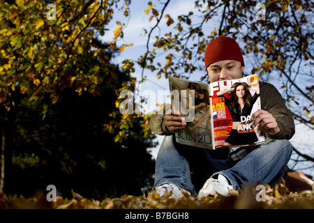 Un uomo che legge un FHM magazine Foto Stock