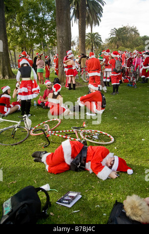 Le coppie di Santa Claus outfits confrontando le istantanee in Los Angeles Foto Stock