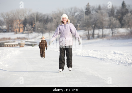 13 year old girl pattinaggio su Red River, Winnipeg, Canada Foto Stock