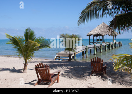 Un gazebo alla fine di un breve molo che si estende dalla spiaggia in Maya Beach Belize sulla penisola di Placencia Foto Stock