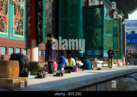 Persone in preghiera presso il Padiglione del grande eroe o Daeung jeon a Jogyesa tempio buddista, Seoul, Corea del Sud Foto Stock