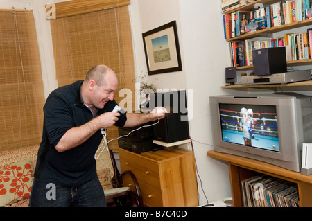 L'uomo gioca su un Nintendo Wii console giochi, England Regno Unito Foto Stock