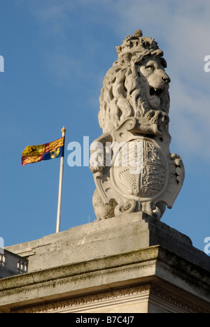 Incoronato lion sulla parte superiore della porta a Buckingham Palace con Royal Standard flying dietro, Westminster, Londra, Inghilterra Foto Stock