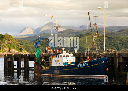 Sera La luce solare che cade su di una barca da pesca a Gairloch Harbour, Wester Ross, Highland, Scozia Foto Stock