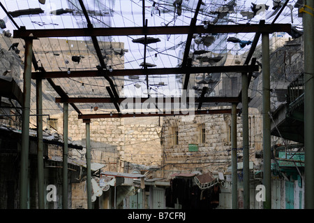 Scena di strada a Hebron sotto occupazione israeliana: un recinto per proteggere pedoni arabi da trashes buttato fuori da coloni ebrei Foto Stock