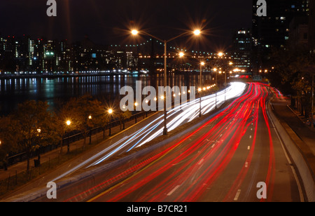 Traffico sfocata visto su FDR Drive lungo la East River di notte nella città di New York, New York, Stati Uniti d'America Foto Stock