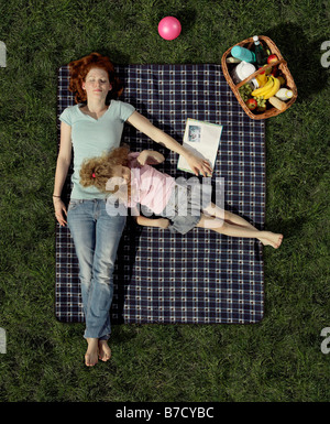 Una madre e figlia giacente su un manto in erba in appoggio Foto Stock