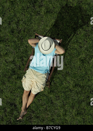 Un uomo seduto su una sedia a sdraio Foto Stock