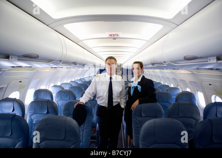 Un pilota e un assistente di volo in piedi nella cabina di un aereo Foto Stock