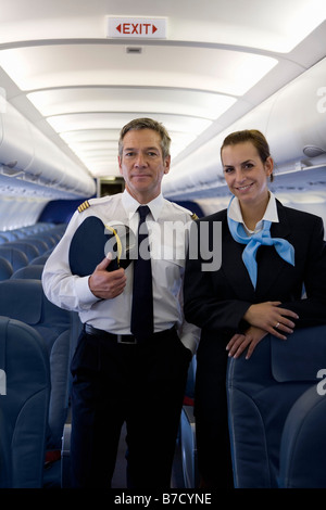 Un pilota e un assistente di volo in piedi nella cabina di un aereo Foto Stock