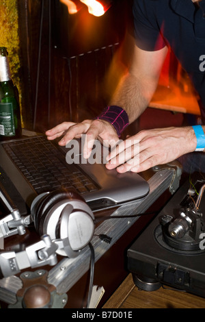 Un DJ usando il suo computer portatile Foto Stock