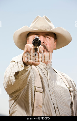 Ritratto di un cowboy puntando la sua pistola pronti a sparare Foto Stock