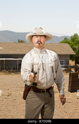 Ritratto di un cowboy puntando la sua pistola Foto Stock