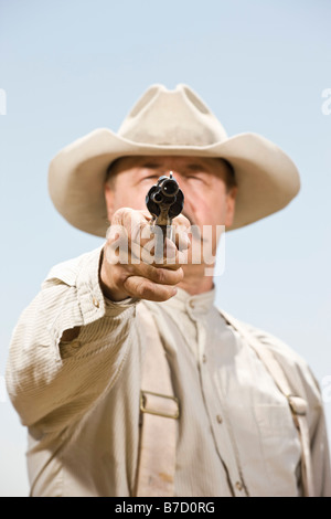 Close up di un cowboy puntando la sua pistola Foto Stock