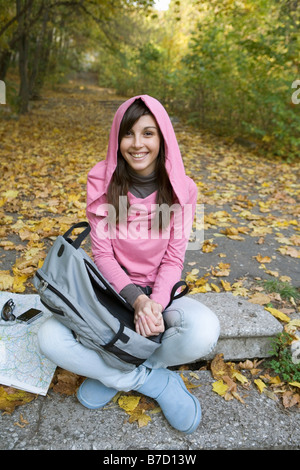 Una ragazza adolescente seduti fuori in natura Foto Stock