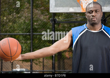 Un giocatore di basket tenendo una palla, ritratto Foto Stock