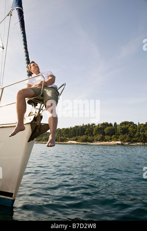 Un uomo seduto sulla prua di una barca Foto Stock