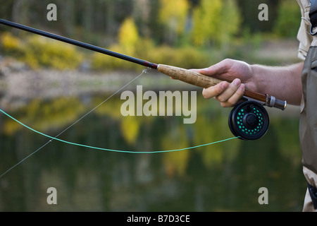 Dettaglio di un uomo con una canna da pesca a mosca Foto Stock