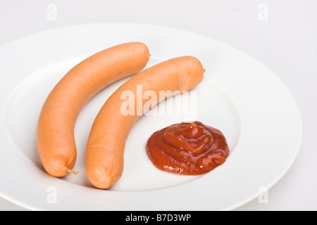 Una coppia di wieners su una piastra bianca Foto Stock