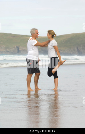 Giovane stretching su una spiaggia Foto Stock