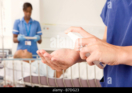 Un infermiere utilizzando antibatterico spray a mano Foto Stock