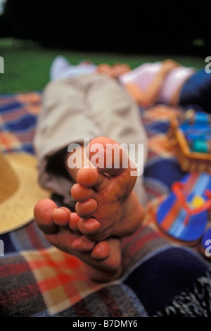 Coppia giovane giacente su un picnic rug. Regno Unito Foto Stock