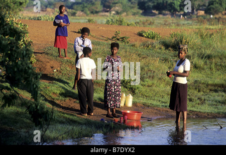 Le donne e i bambini a waterhole, Zambia Foto Stock